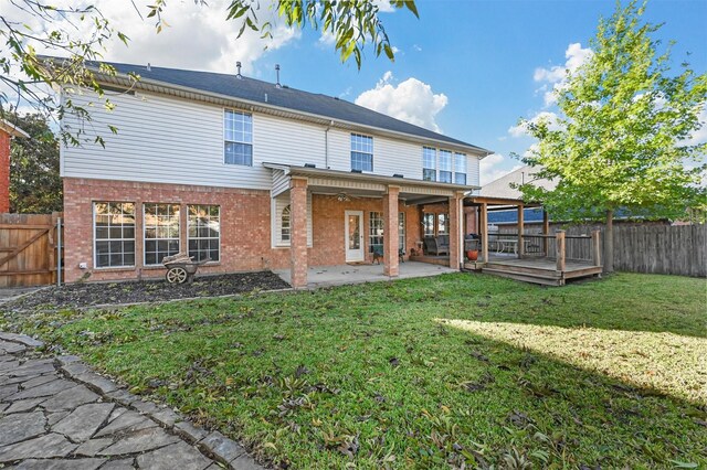 rear view of house featuring a yard, a deck, and a patio area