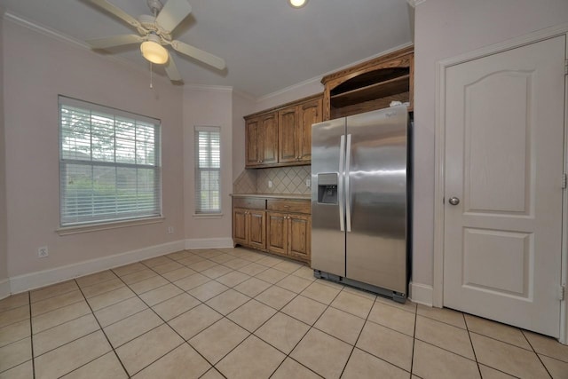 kitchen with light tile patterned floors, crown molding, ceiling fan, stainless steel fridge with ice dispenser, and decorative backsplash