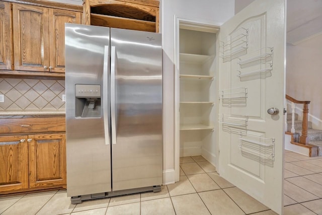 kitchen with backsplash, light tile patterned flooring, and stainless steel refrigerator with ice dispenser