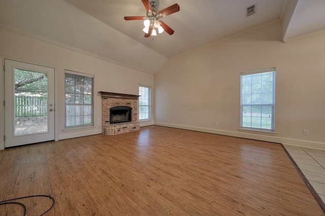 unfurnished living room featuring ceiling fan, a fireplace, ornamental molding, light hardwood / wood-style floors, and vaulted ceiling