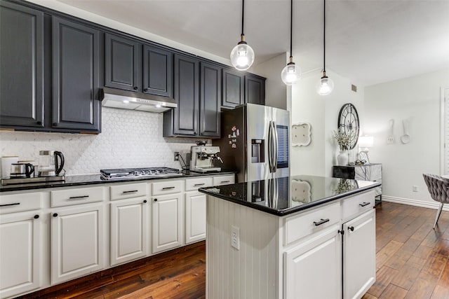 kitchen with under cabinet range hood, dark wood-type flooring, appliances with stainless steel finishes, decorative backsplash, and pendant lighting