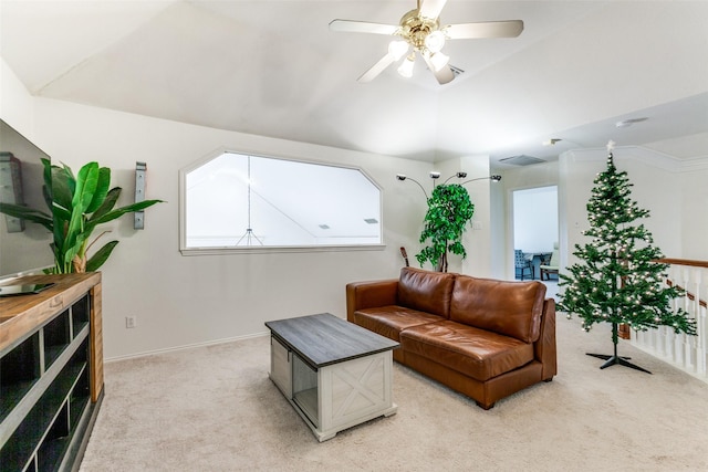 living area featuring lofted ceiling, baseboards, a ceiling fan, and light colored carpet