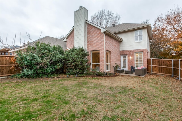 rear view of property featuring a fenced backyard, brick siding, outdoor lounge area, a lawn, and a chimney