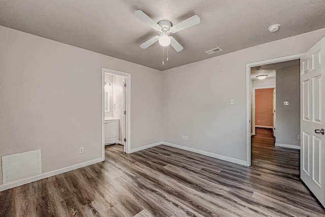 unfurnished bedroom featuring ceiling fan, dark hardwood / wood-style floors, and ensuite bathroom