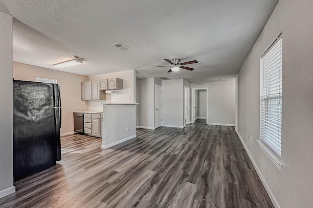 unfurnished living room featuring a textured ceiling, ceiling fan, and dark wood-type flooring