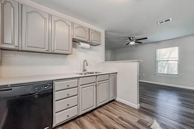 kitchen with sink, decorative backsplash, ceiling fan, black dishwasher, and wood-type flooring