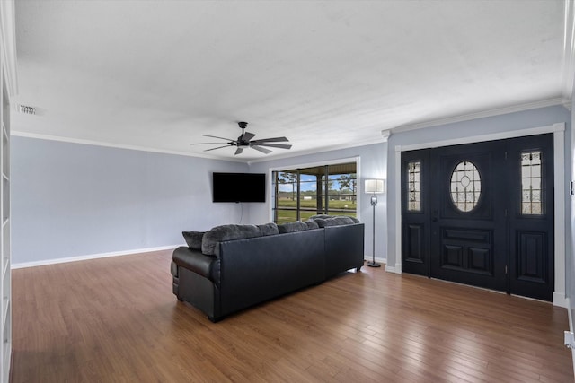 living room featuring dark hardwood / wood-style flooring, crown molding, and ceiling fan