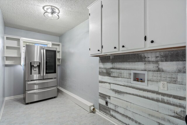 laundry area featuring cabinets, washer hookup, and a textured ceiling