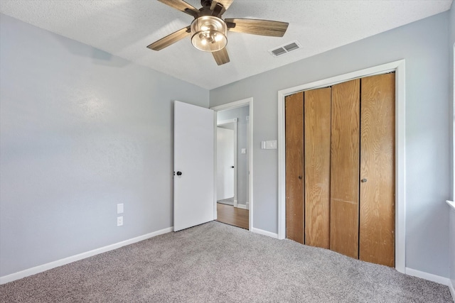 unfurnished bedroom with carpet, a textured ceiling, ceiling fan, and a closet