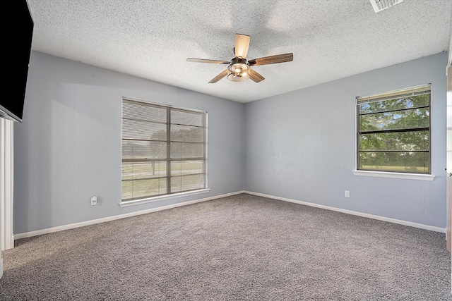 carpeted empty room with ceiling fan and a textured ceiling