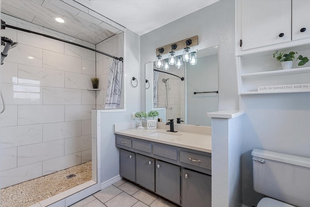 bathroom with tile patterned flooring, vanity, curtained shower, and toilet