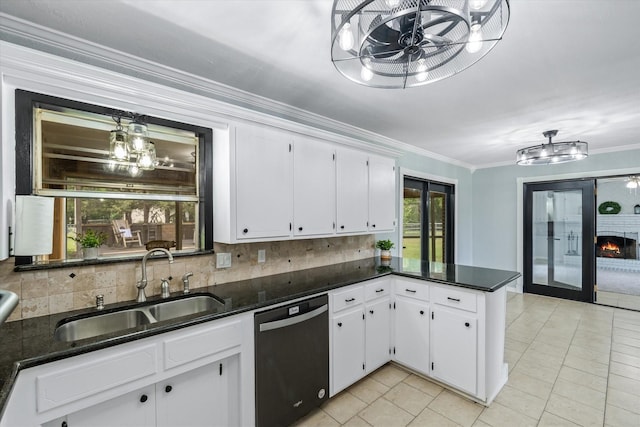 kitchen featuring pendant lighting, dishwasher, sink, white cabinets, and decorative backsplash