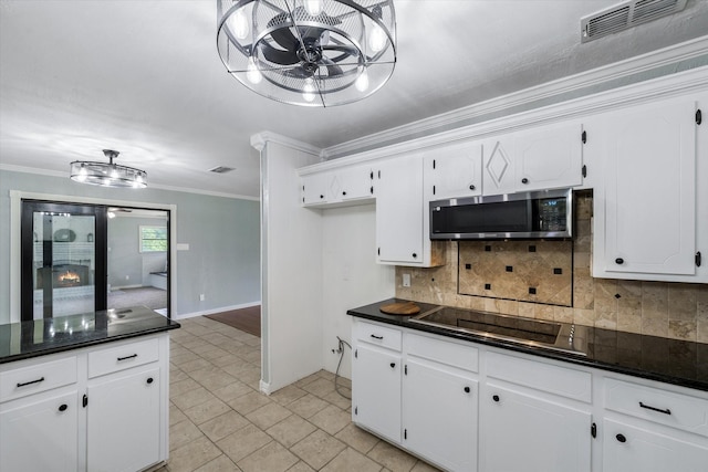 kitchen with tasteful backsplash, ornamental molding, black electric stovetop, and white cabinets