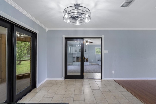 interior space with an inviting chandelier, ornamental molding, light tile patterned flooring, and a wealth of natural light