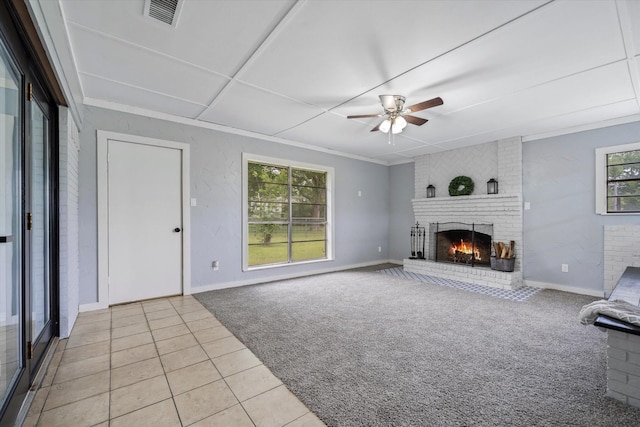 unfurnished living room featuring ceiling fan, a brick fireplace, and light tile patterned floors