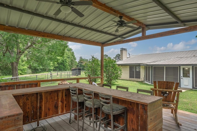 deck featuring ceiling fan and exterior bar