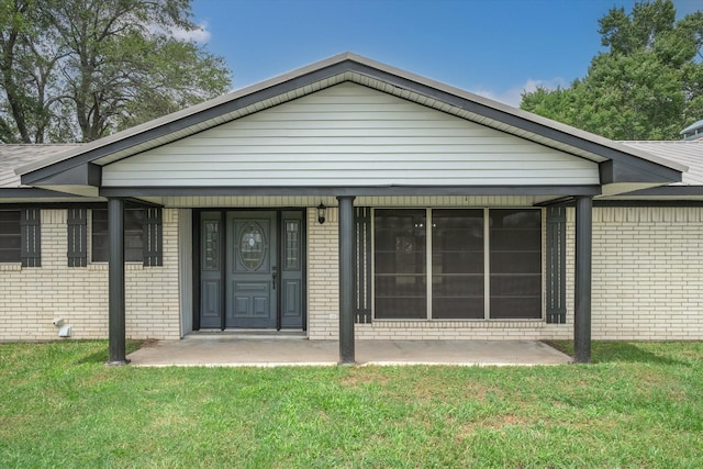 doorway to property with a lawn