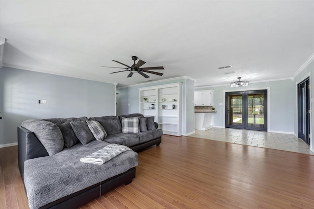 living room with ornamental molding, light hardwood / wood-style floors, french doors, and ceiling fan