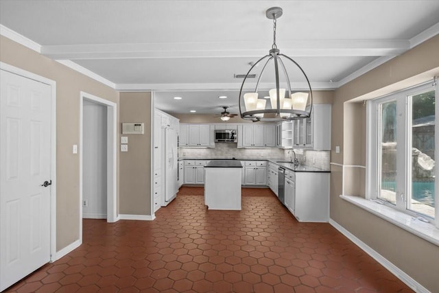 kitchen featuring white cabinetry, sink, backsplash, decorative light fixtures, and appliances with stainless steel finishes