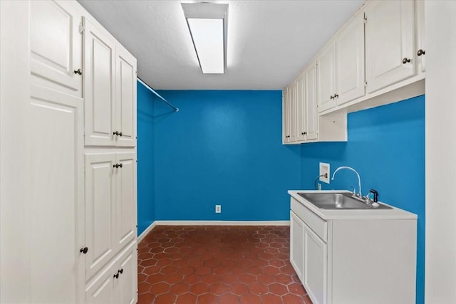 clothes washing area with hookup for a washing machine, sink, and cabinets