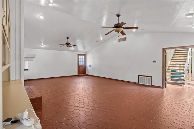 unfurnished living room with a textured ceiling, ceiling fan, and lofted ceiling