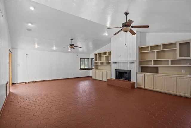 unfurnished living room with a large fireplace, vaulted ceiling, and ceiling fan