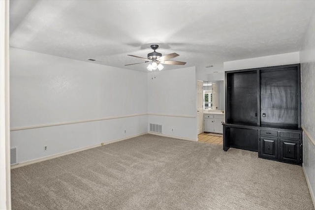 interior space featuring ceiling fan and light colored carpet