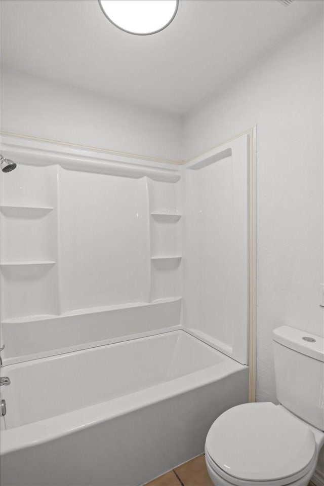 bathroom featuring tile patterned floors, toilet, and shower / tub combination