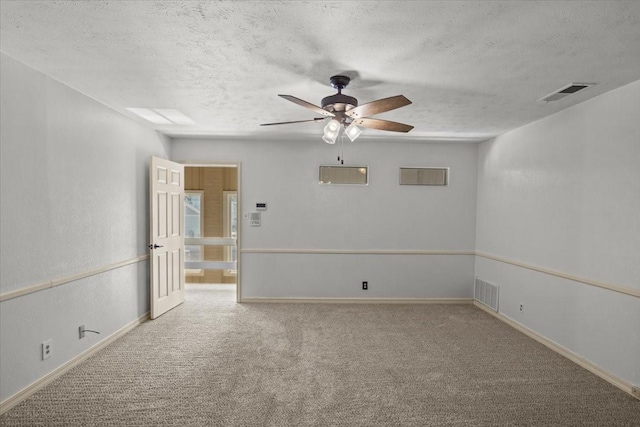 carpeted spare room with ceiling fan and a textured ceiling