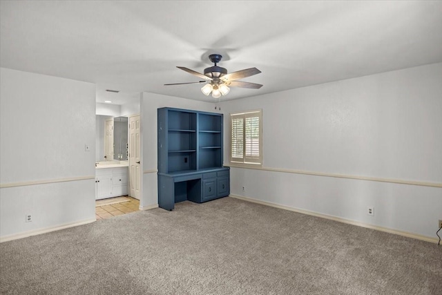 unfurnished bedroom with connected bathroom, light colored carpet, and ceiling fan