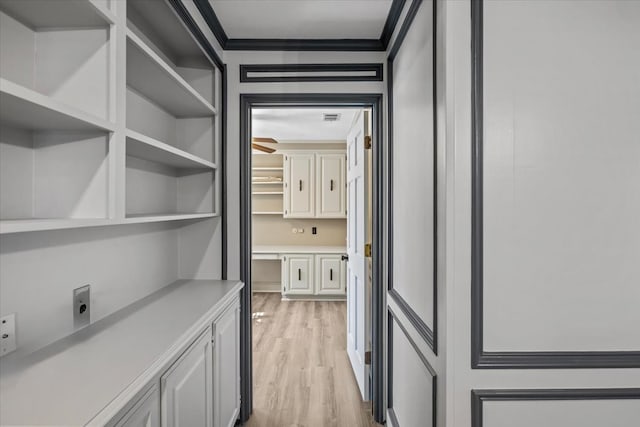 hallway featuring light hardwood / wood-style floors and ornamental molding