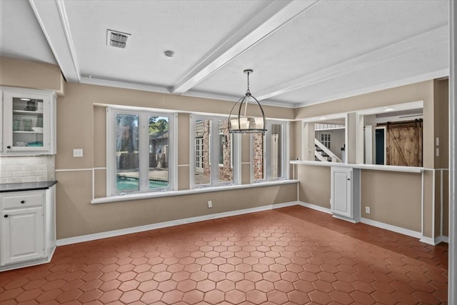 unfurnished dining area with beam ceiling and a barn door