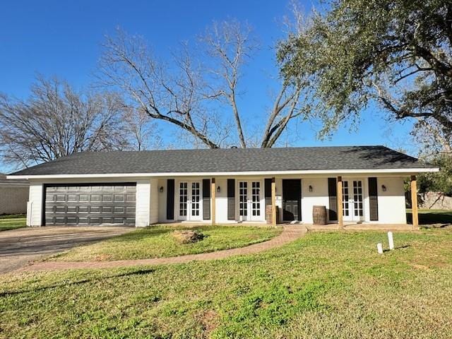 ranch-style house featuring a front yard, french doors, and a garage