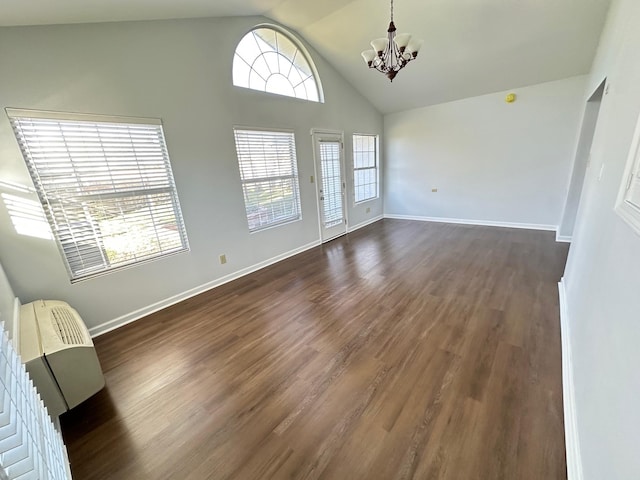 unfurnished living room with vaulted ceiling, a chandelier, and dark hardwood / wood-style floors