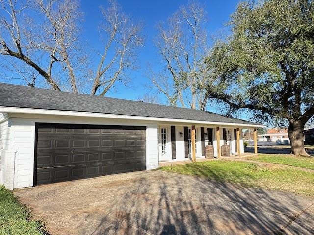 single story home featuring covered porch and a garage