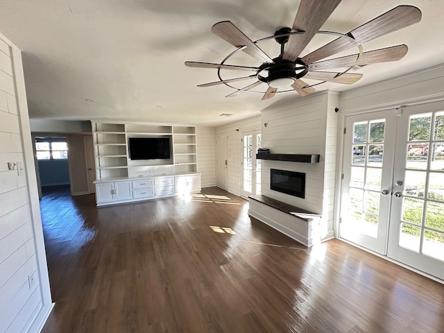 unfurnished living room featuring ceiling fan, french doors, and wood-type flooring