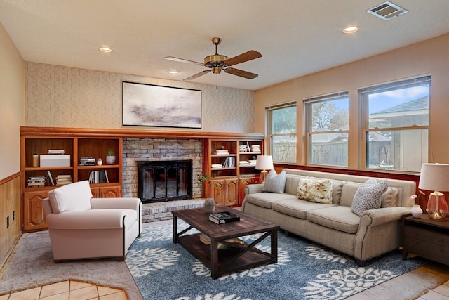 living room featuring ceiling fan and a fireplace