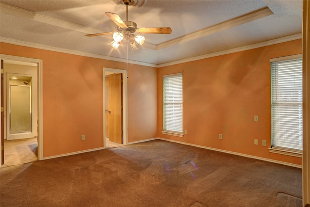 unfurnished bedroom featuring a tray ceiling, ornamental molding, and carpet