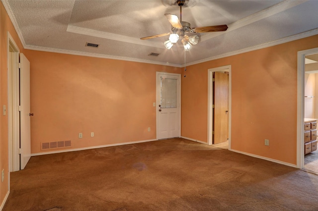 spare room with ceiling fan, carpet, a tray ceiling, ornamental molding, and a textured ceiling