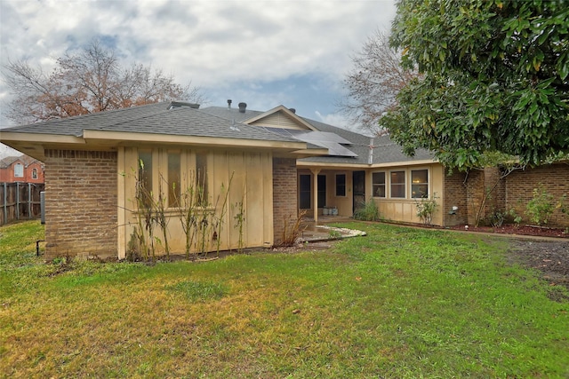 rear view of property featuring a lawn