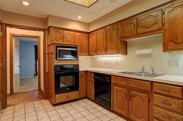 kitchen with sink, black appliances, a textured ceiling, and light tile patterned flooring