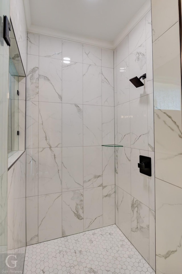 bathroom featuring a tile shower and crown molding