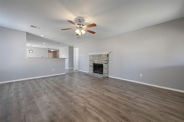 unfurnished living room with hardwood / wood-style floors, a fireplace, and ceiling fan