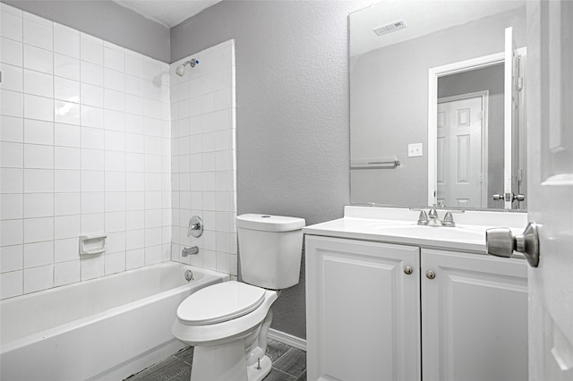 full bathroom with vanity, tiled shower / bath combo, and toilet