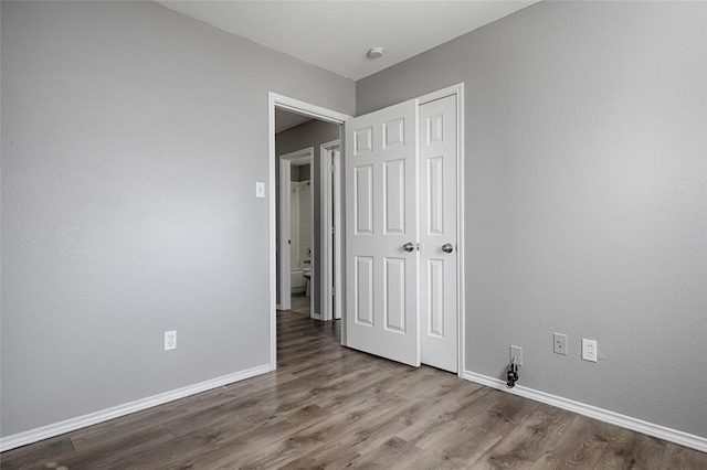 unfurnished bedroom featuring wood-type flooring and a closet