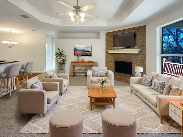 carpeted living room featuring ceiling fan with notable chandelier, a raised ceiling, and crown molding