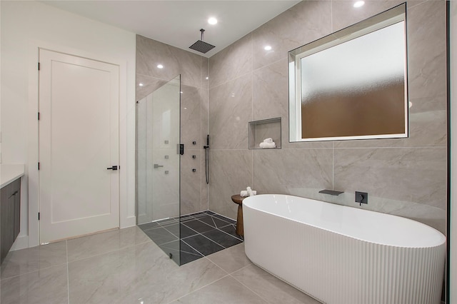 bathroom with tile walls and independent shower and bath