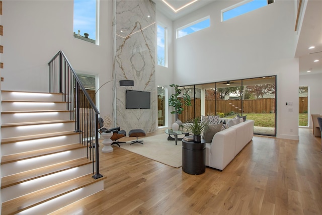 living room featuring light wood-type flooring and a high ceiling