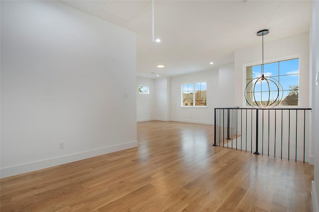 unfurnished room featuring light hardwood / wood-style floors and a chandelier