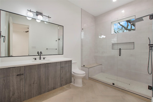 bathroom with tile patterned flooring, vanity, a shower with shower door, and toilet